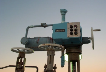 Teal electric valve actuator installed outdoors on valve equipment